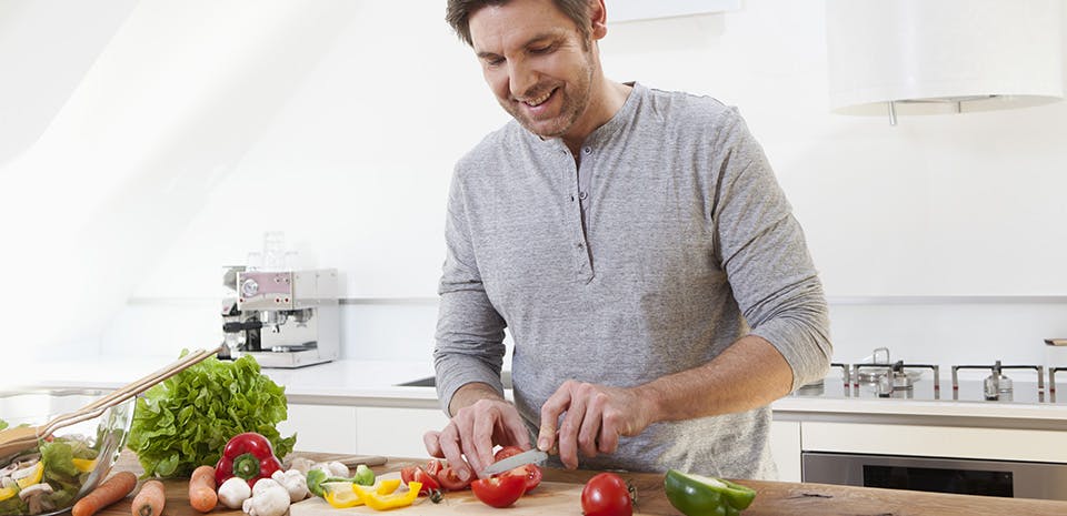 Man cutting vegetables in the kitchen | Eat sleep-promoting foods