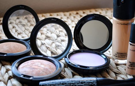 Three finishing powders, mascara and nail gels on table Three finishing powders, mascara and nail gels on table