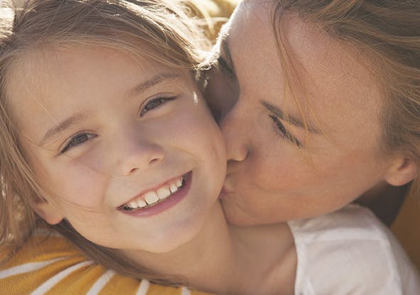 Mother kissing daughter 