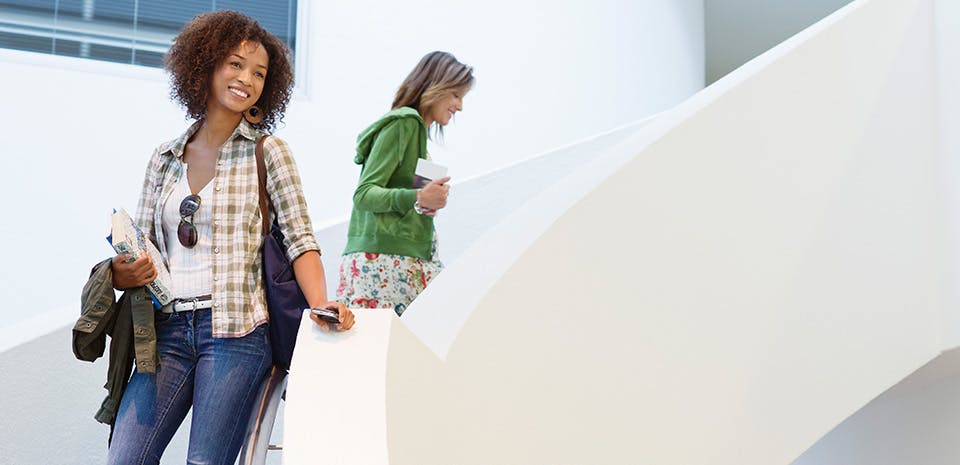 Woman smiling and standing on a set of stairs | Walk it out Woman smiling and standing on a set of stairs | Walk it out