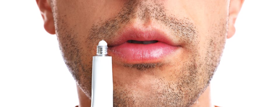 Man preparing to use cold sore ointment Man preparing to use cold sore ointment