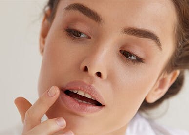 Woman applying lip balm in mirror