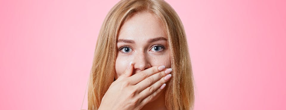 Young woman covering her nose and mouth