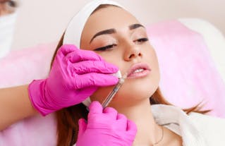 young woman getting lip filler injection