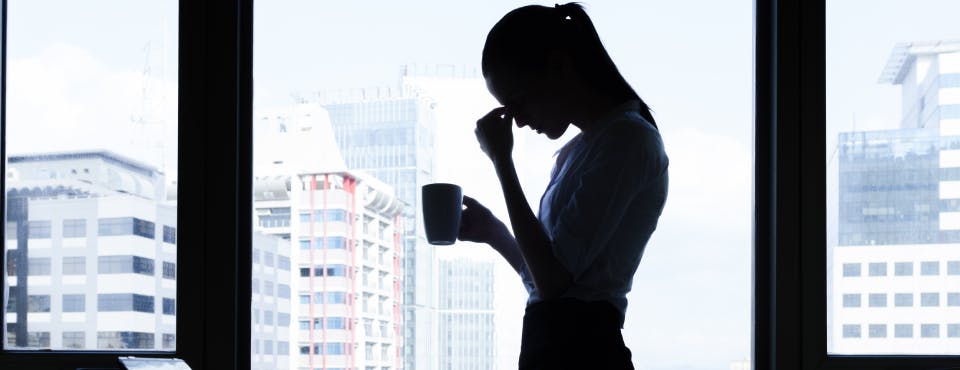 Silhouette of stressed business woman in high-rise building