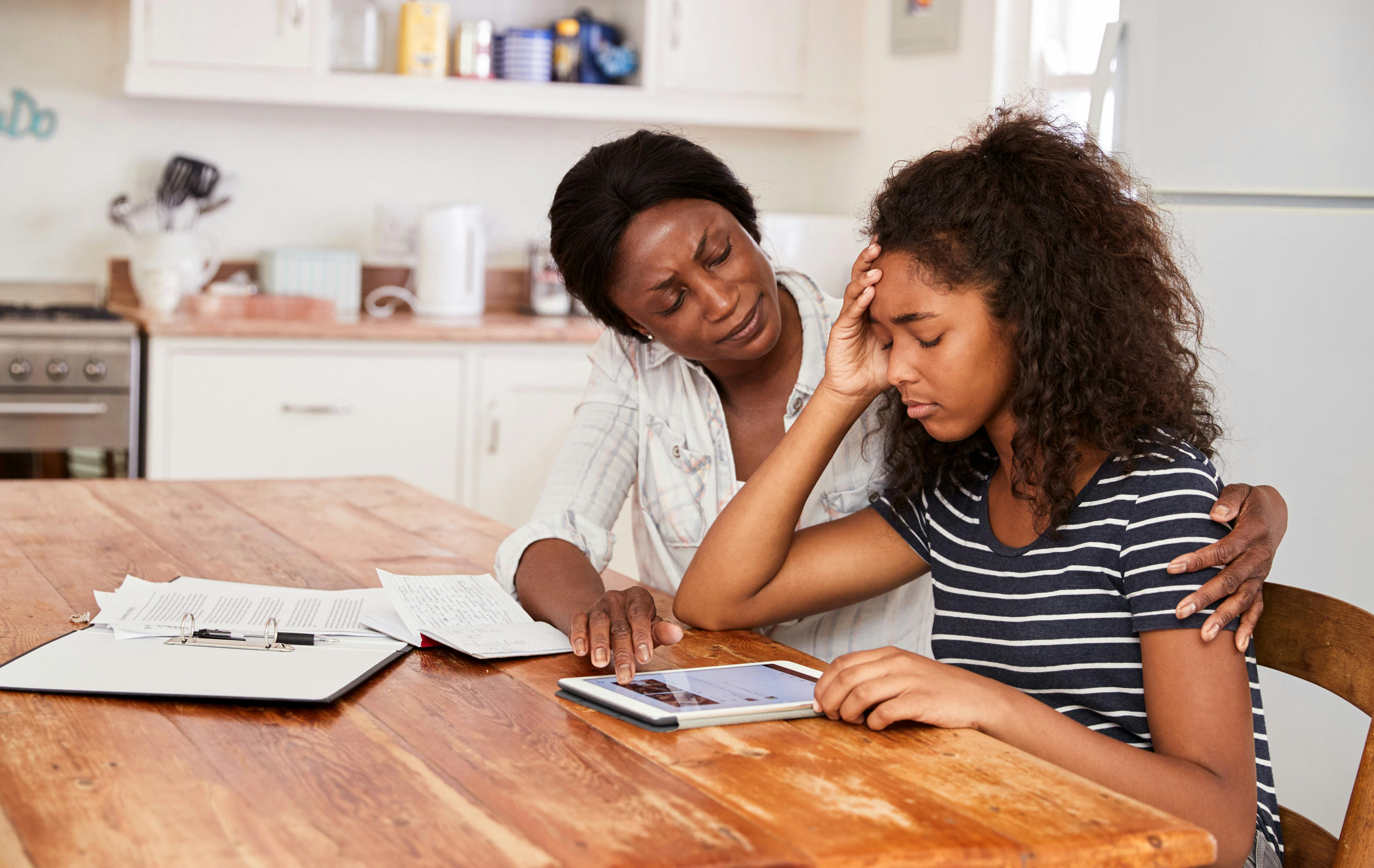 A mother consoling her stressed teenage daughter