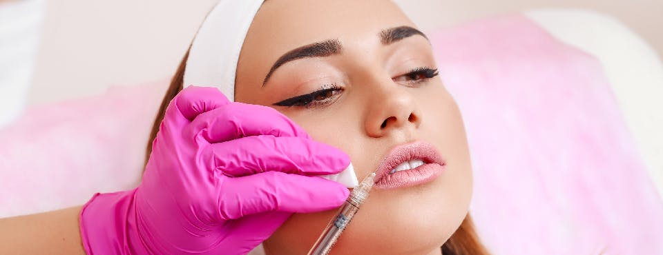 young woman getting lip filler injection
