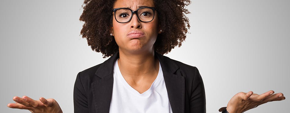 black woman in jacket and glasses looking confused