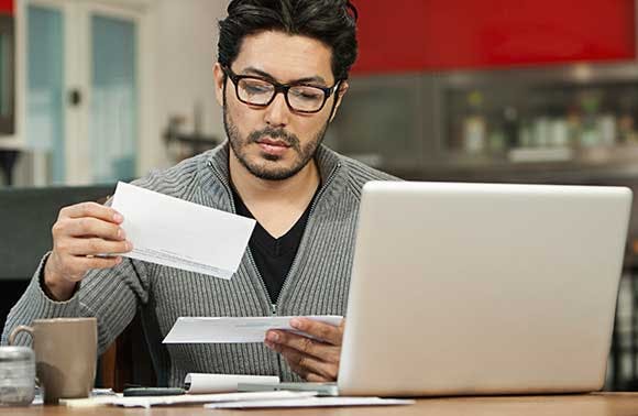 Un homme assis à son bureau parcourant le courrier