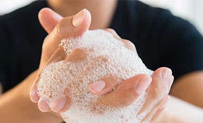 Une personne se lavant les mains avec du savon