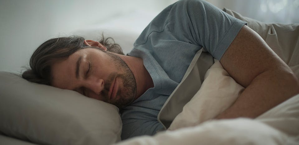 Un homme dormant dans son lit