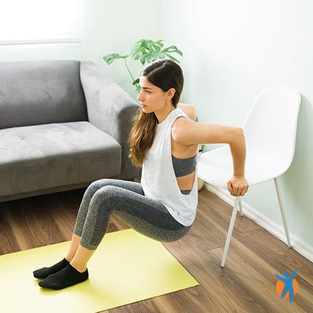 Vrouw doet yoga met een stoel om rugpijn te verlichten