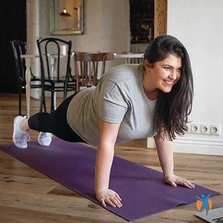 Vrouw die yoga voor laptop doet voor een at home training