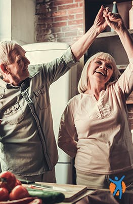 Elderly couple happily dancing in the kitchen