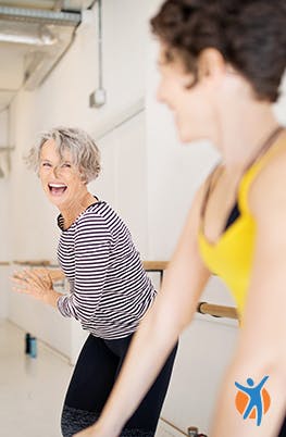 Zwei Frauen beim Sportkurs, sie haben Spaß