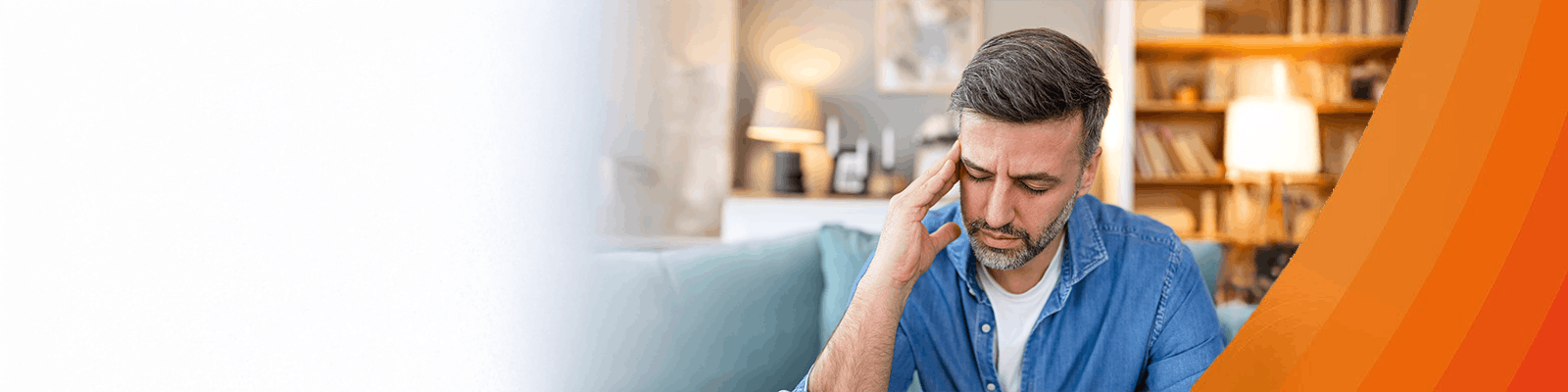 Mann mit Kopfschmerzen fasst sich an die Schläfen.