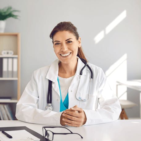 Freundliche Ärztin lächelt in die Kamera.