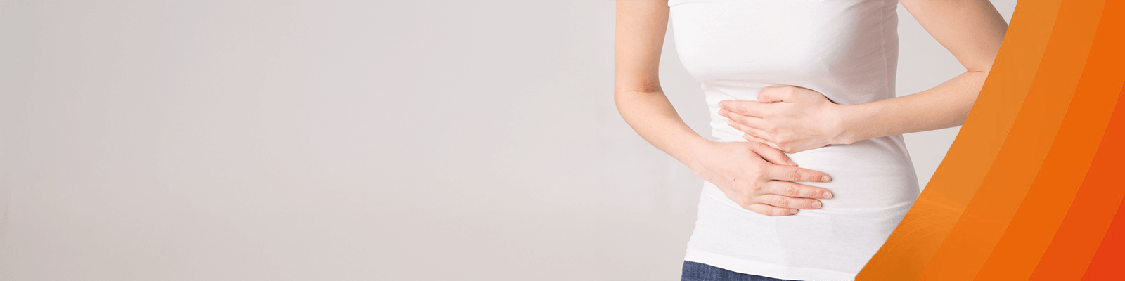 Frau mit Regelschmerzen fasst sich an den Bauch.