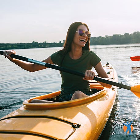 Smiling young woman kayaking on a lake