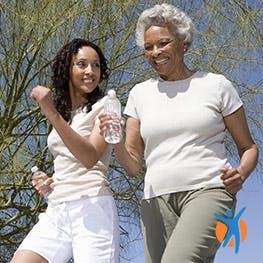 An elderly women and younger women walking outside