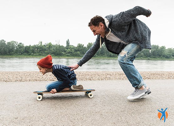 A father pushing his child on a skateboard