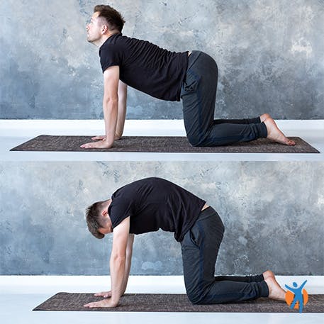 Man doing cat Chakravakasana, cat-cow yoga pose to target lower back pain