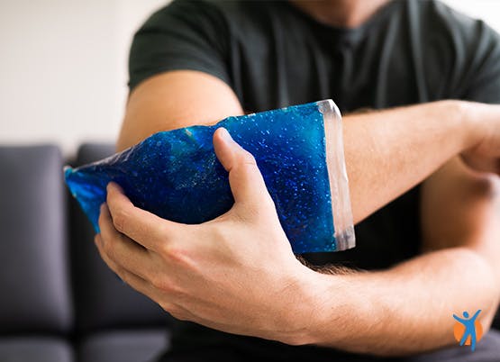 Icing your joints to help with Osteoarthritis pain Man using a cold ice pack on his elbow - an effective way to get short-term relief from osteorthritis