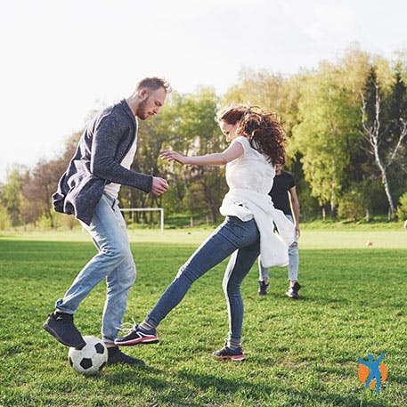 Young couple playing football in the park