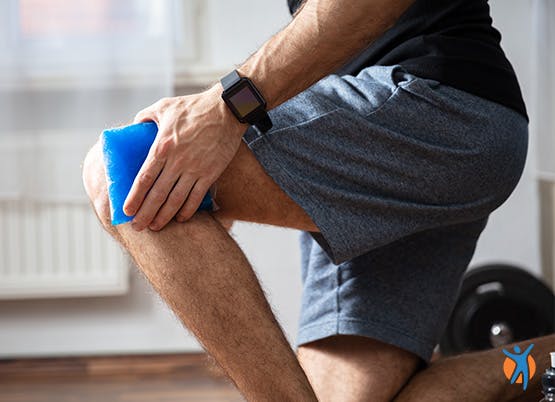 Man uses ice pack on knee pain as part of RICE method