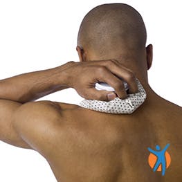 Man applying an ice+D6 pack to his neck, an effective neck pin remedy.