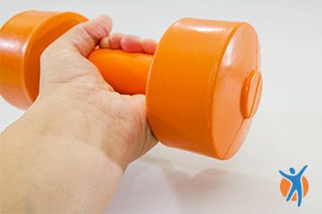 Close of hand holding a dumbbell for wrist curl exercises Close of hand holding a dumbbell for wrist curl exercises
