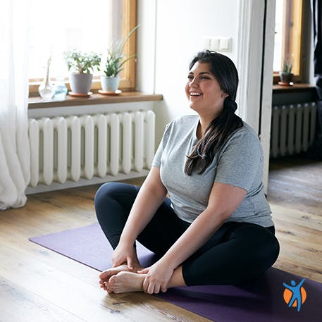 Woman sitting at home doing yoga class