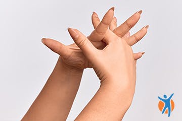 Close up of two hands with interlaced fingers and hands open for yoga wrist exercises