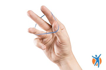 Close up of fingers spread-apart with rubber band for wrist pain relief Close up of fingers spread-apart with rubber band for wrist pain relief