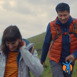 A young couple walking on the hills - learn how Voltarol helps relieve inflamatory back pain