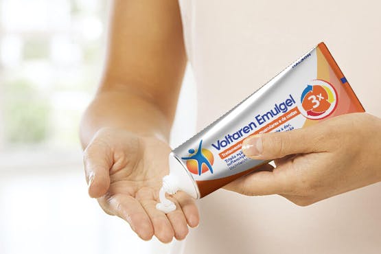 Woman squeezing Voltarol gel on hand Woman squeezing Voltarol gel on hand