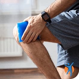 Man uses ice pack on knee pain as part of RICE method