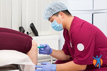 Medical Doctor administering injection into joint to relieve pain Medical Doctor administering injection into joint to relieve pain