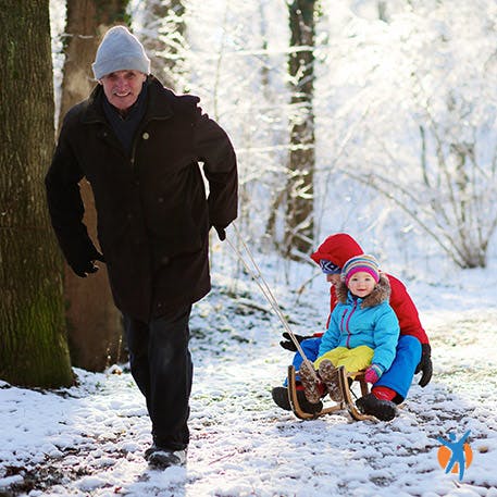 Man pulls children on sled - Voltarol heat patches provide muscle pain relief and deep relaxation
