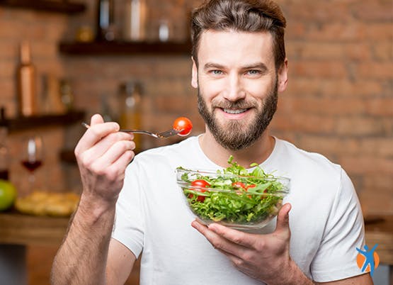 Man eating healthy salad - eat a nutritious diet to reduce the inflamation and osteoarthritis pain Man eating healthy salad - eat a nutritious diet to reduce the inflamation and osteoarthritis pain