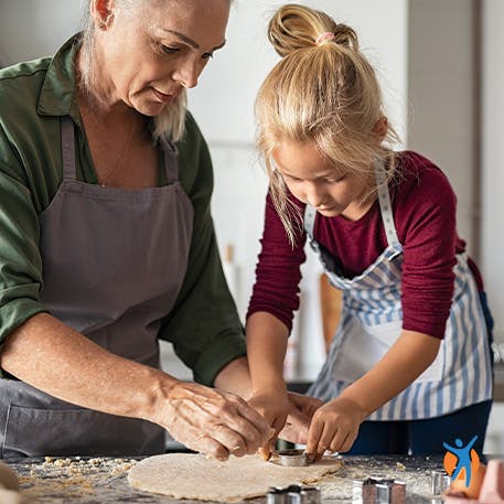 Getting back to normal with Voltaren pain relief gel Woman cooking with her daughter - Voltarol helps relieve wrist and hand pain