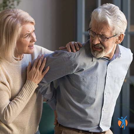 Woman consoling man experiencing back muscle pain