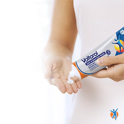 Woman squeezing Voltarol gel on hand Woman squeezing Voltarol gel on hand