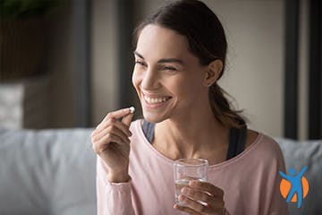 Woman taking oral medication to relieve osteoarthritis pain