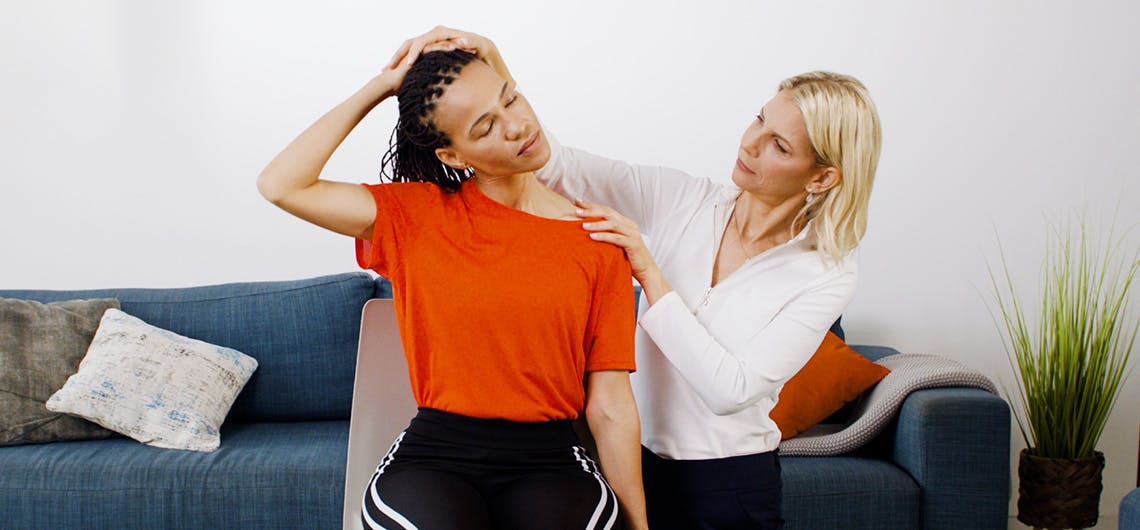 A woman helping other woman with neck pain