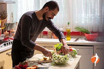 Woman in kitchen holding her lower back