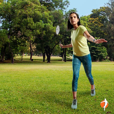 Woman playing badminton in the field Woman playing badminton in the field