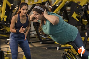 Woman exercising under guidance of her trainer