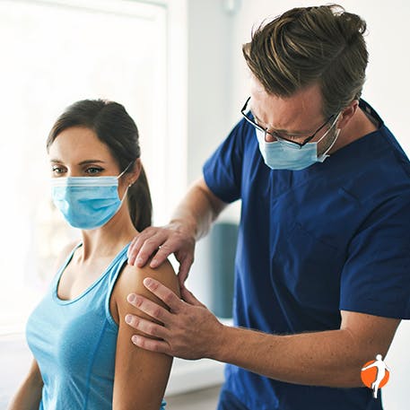 Woman being examined by doctor for shoulder pain