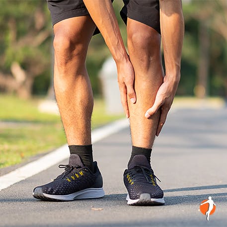 Foot and ankle pain symtpoms Man holding his shin and calf
